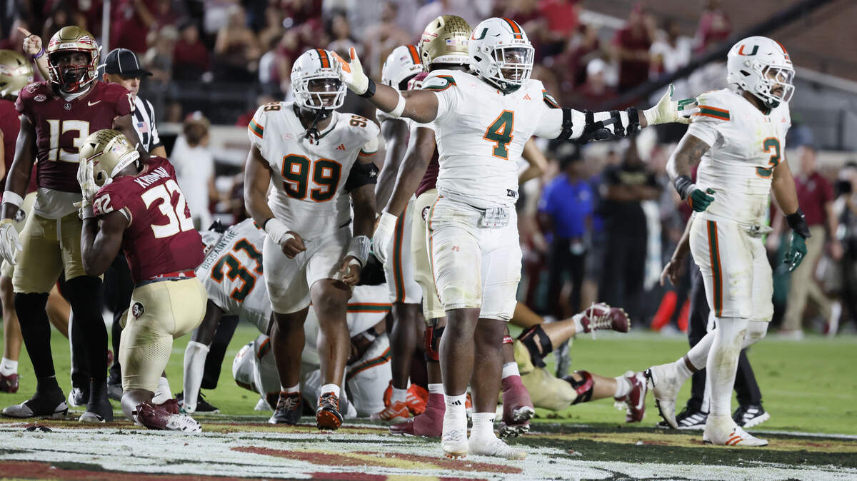 Miami Hurricanes defensive lineman Rueben Bain Jr. (4) and defensive lineman Ahmad Moten Sr. (99) react after defensive back Keionte Scott (0) recovers a fumble in the first half against the Florida State Seminoles at Doak Campbell Stadium in Tallahassee, Florida, on Saturday, October 4, 2025.
