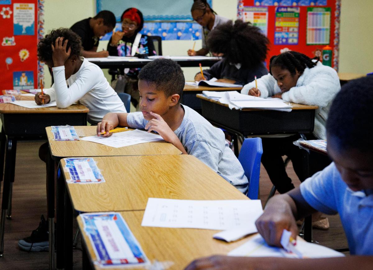 Elijah, center, works on homework with other fourth graders during the afternoon on Wednesday, Nov. 13, 2024, at Liberty Academy, a school and aftercare facility in Liberty City.
