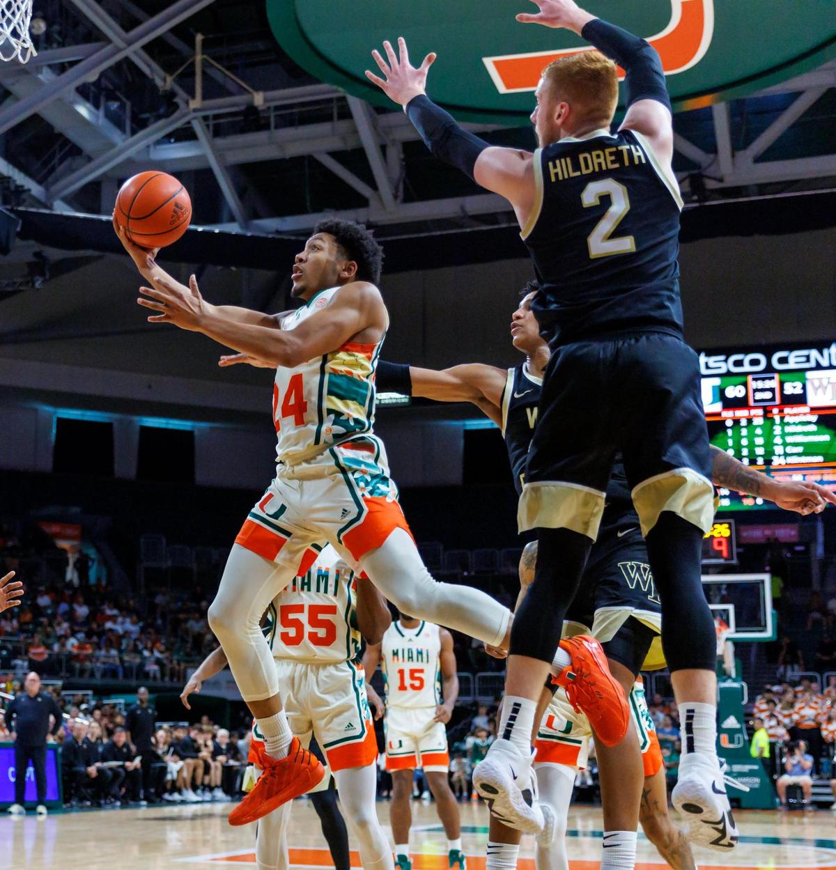 Miami Hurricanes guard Nijel Pack (24) goes to the basket against Wake Forest Demon Deacons guard Cameron Hildreth (2) and Demon Deacons forward Bobi Klintman (34) during the second half of an NCAA college basketball game at Watsco Center on Saturday, February 18, 2023 in Coral Gables, Florida.