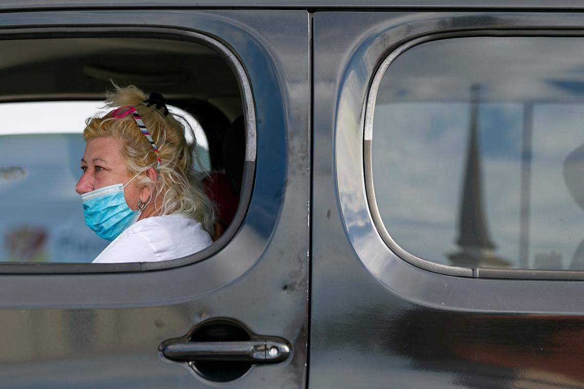 Omayra Suarez waits in her car as helpers load up her vehicle during a drive-thru food distribution event in Hialeah on Saturday, December 5, 2020.