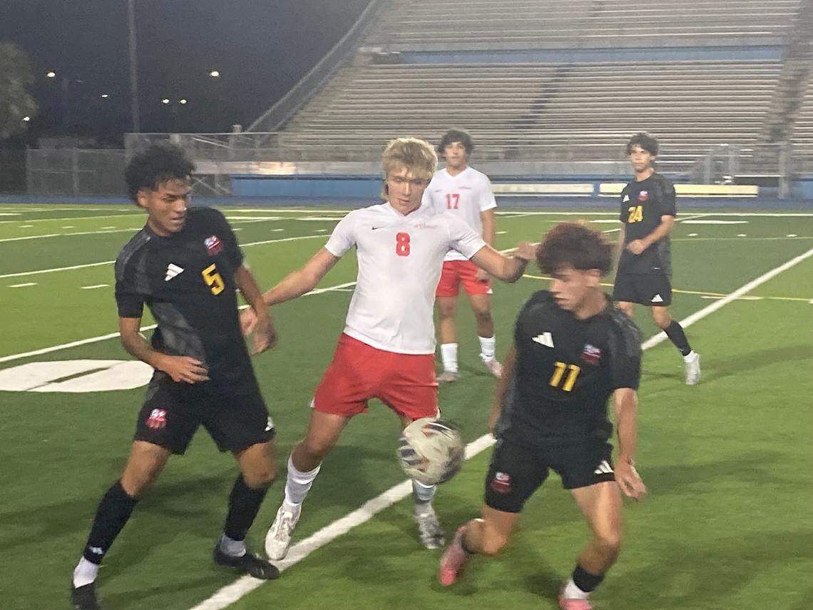 MAST Academy’s Guilhermo Volkart (8) battles Miami Beach defenders Josmel Nuñez (5) and Tomas Visintini for a loose ball during Friday’s GMAC championship at Traz Powell Stadium.