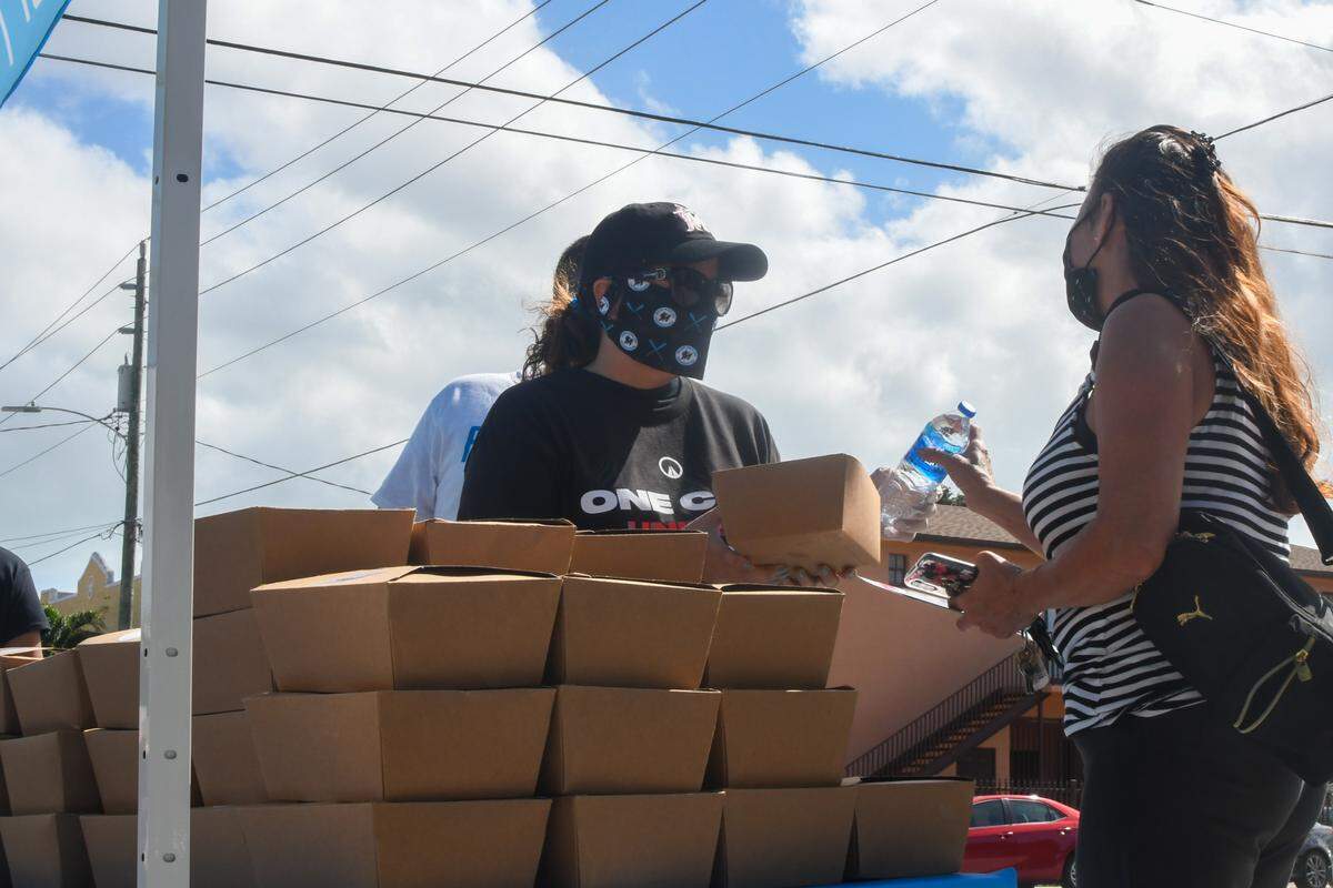 Miami Marlins Foundation executive director Raquel “Rocky” Egusquiza hands out a meal at the Citrus Grove Middle School polling location in Little Havana, Florida, on Tuesday, Nov. 3, 2020. The Miami Marlins Foundation in partnership with Feed The Polls gave away 4,000 meals at two polling locations on Election Day.