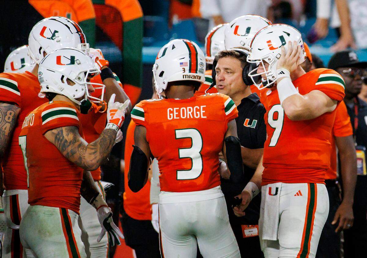 Miami Hurricanes Offensive Coordinator / Quarterbacks Coach Shannon Dawson talk with Hurricanes wide receivers Xavier Restrepo (7) Jacolby George (3) and Hurricanes quarterback Tyler Van Dyke (9) during the fourth quarter of an NCAA non conference game against Texas A&M at Hard Rock Stadium on Saturday, Sept. 9, 2023 in Miami Gardens, Florida.