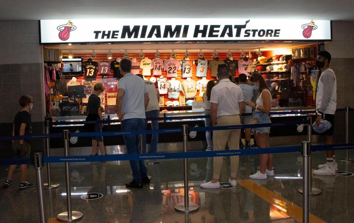 Fans wearing protective mask buying Heat merchandise before the start of an NBA basketball game between the Miami Heat against the Golden State Warriors at the AmericanAirlines Arena on Thursday, April 1, 2021 in Miami, Fl. The Heat increase the number of fans allowed to attend games at AmericanAirlines Arena to about 4,000 just about 20 percent of the building’s usual capacity of 19,600.
