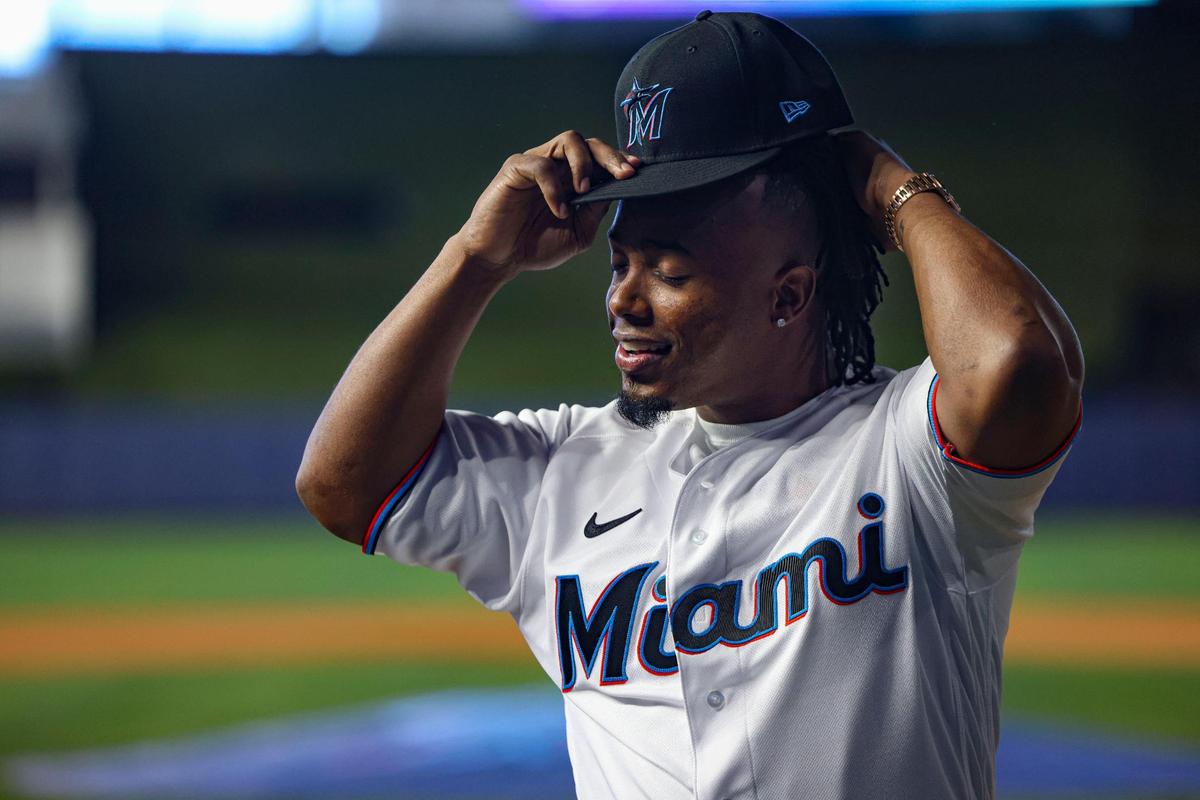Jean Segura, new Miami Marlins infielder, puts on his hat and jersey after receiving it as a welcome to the team on Wednesday, Jan. 11, 2023, at loanDepot Park.