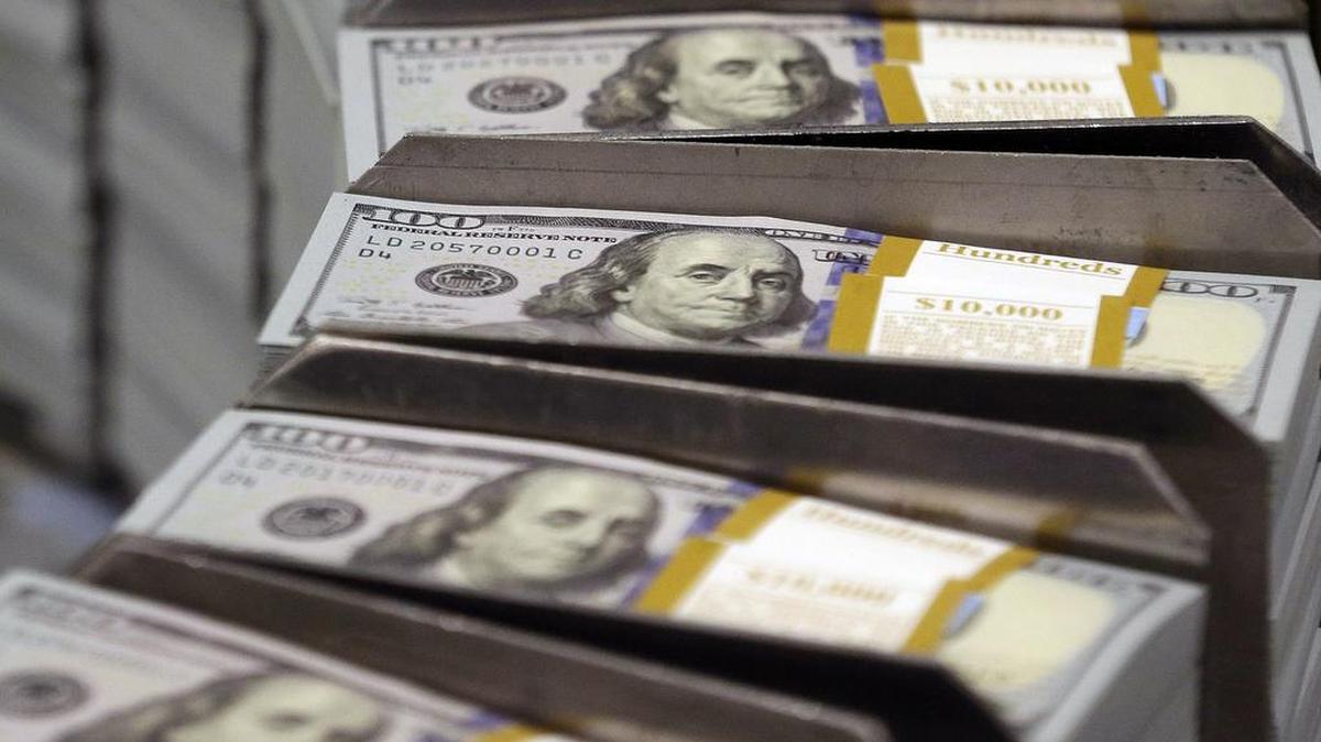 Freshly cut stacks of $100 bills make their way down the line at the Bureau of Engraving and Printing Western Currency Facility in Fort Worth, Texas., in 2013. Quarterly earnings season begins in earnest with more than a half-dozen big banks, like Wells Fargo, Bank of America and J.P. Morgan, scheduled to released their latest financial results.