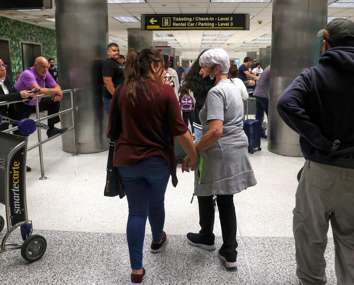 Graciela Silva, right, who was on the Red Air flight that caught fire, reunites with her daughter, Jasmine Rincon, after getting off the plane on Tuesday, June 21, 2022, at Miami International Airport.