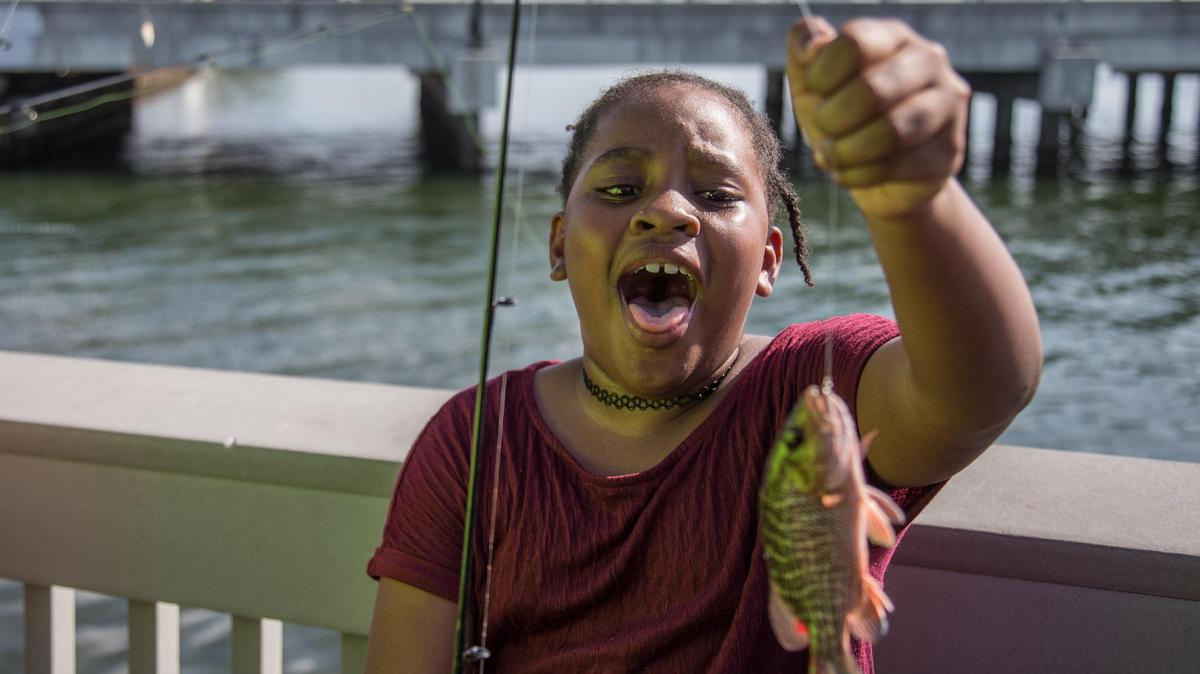 Ruthney Bernard, 7, reacts to catching her first fish during the Cops and Kids event hosted by the North Miami Police Department at North Bayshore William Lehman Park, Saturday, July 21, 2018. Officers from North Miami Police Department engaged with the community for a fun day of fishing.