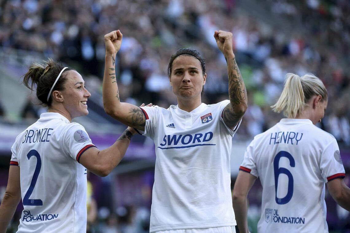 Dzsenifer Marozsan of Lyon, center, celebrates the opening goal with her teammates Lucy Bronze, left, and Amandine Henry, right, during the women’s soccer UEFA Champions League final match between Olympique Lyon and FC Barcelona at the Groupama Arena in Budapest, Hungary, Saturday, May 18, 2019.