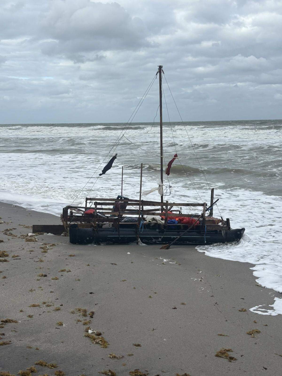 A makeshift migrant boat rests beached on Jupiter Island in Martin County Saturday, Oct. 25, 2025.