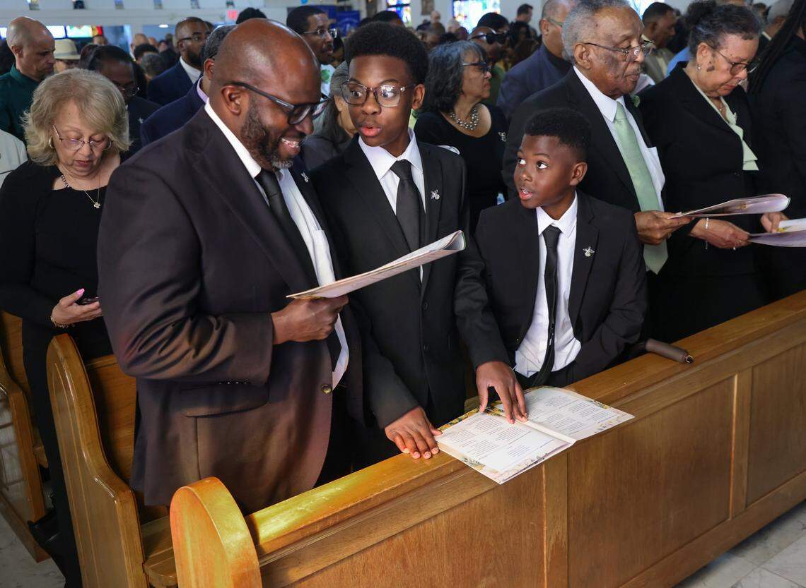 Grandson Charles Gibson, left, sings with his sons - Grant, and Winston, center, as four generations of family members, dignitaries, politicians, friends, and Coconut Grove residents gathered at Christ Episcopal Church to honor Thelma Gibson, a community leader who died 10 months before her 100th birthday. The service was held at the church where Gibson was baptized on Friday, February 27, 2026, in Miami, Florida.