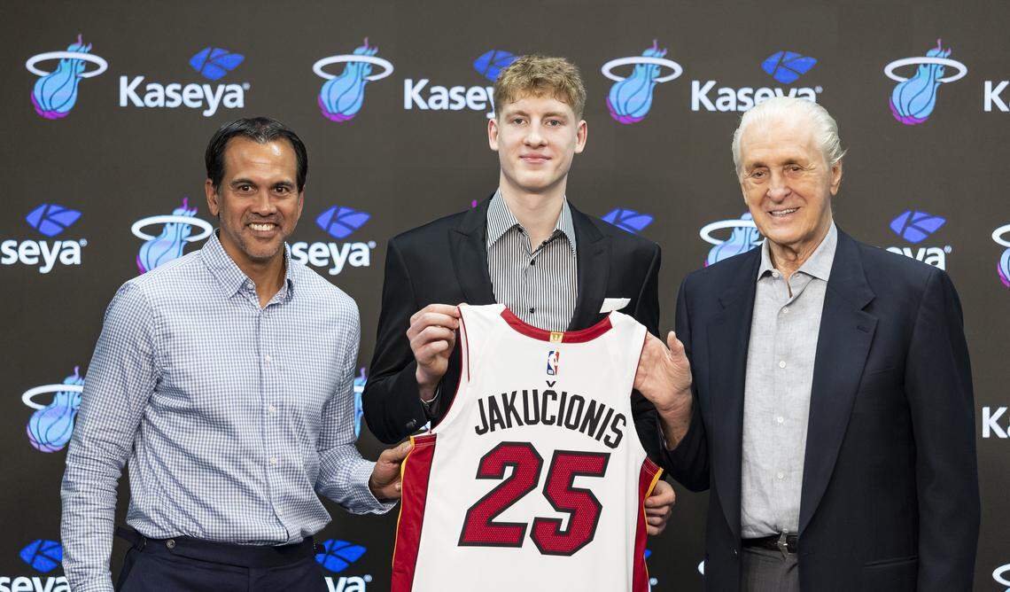 Miami Heat first-round pick Kasparas Jakucionis holds his jersey alongside team president Pat Riley and head coach Erik Spoelstra during his introductory press conference at Kaseya Center on June 27, 2025, in Miami.