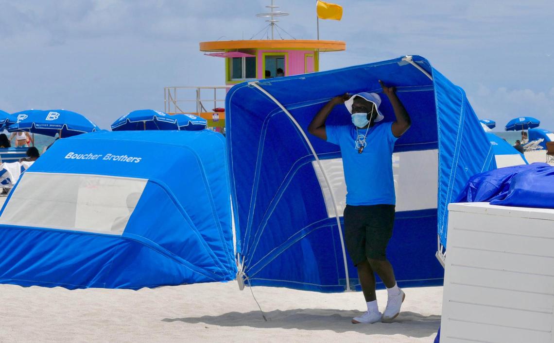 Rolsen Cheristil, 17, sets up a beach shade for customers on south beach Saturday afternoon. Cheristil works for Boucher brothers beach chairs and they were busy Saturday, even running out of day beds for sunbathers at the beach.