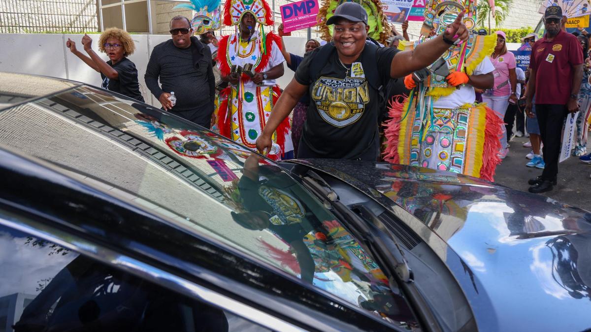Un trabajador electoral ayuda a un automovilista a pasar entre la multitud mientras se dirige a las urnas. Candidatos demócratas, la alcaldesa Daniella Levine Cava y los residentes de zonas no incorporadas de Miami-Dade bailaron hacia las urnas en el Centro Joseph Caleb durante el evento Souls to the Polls en el último día de votación anticipada, el domingo 3 de noviembre de 2024 en Miami, Florida.