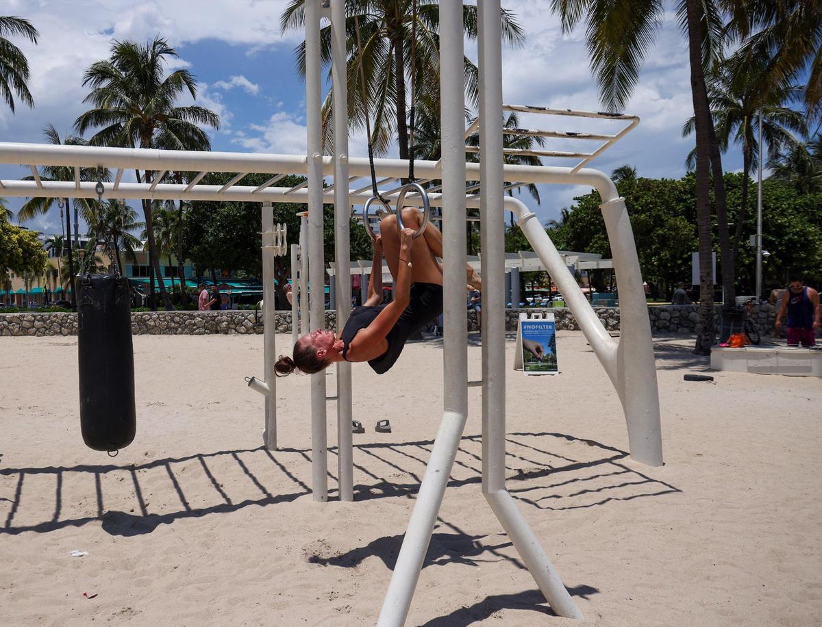 Juliette Lux, de 23 años, habitante de South Beach, haciendo ejercicio en My Equilibra, un parque de bienestar, bajo el sol de las 12:00 p.m., cuando la temperatura superaba los 90 grados en Miami Beach, la Florida.