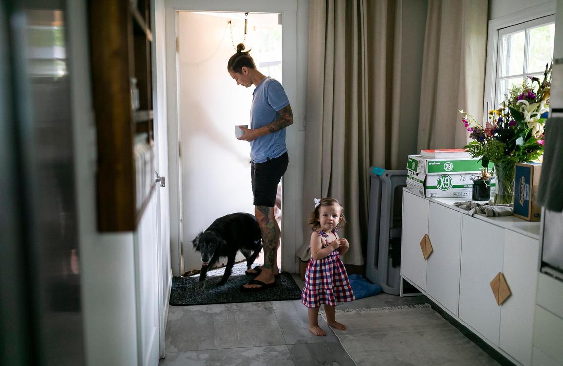Broward Sheriff’s Office Battalion Chief Nichole Notte, 41, opens the door for her dog, Dig, while her daughter, Luca, 1, stands nearby at their home on Tuesday, June 21, 2022 in Fort Lauderdale, Fla.