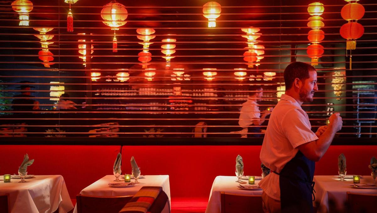 Chef Adrian Ochoa passes the long mirrored wall at Double Luck Chinese restaurant, which was named as a Michelin Guide Bib Gourmand.