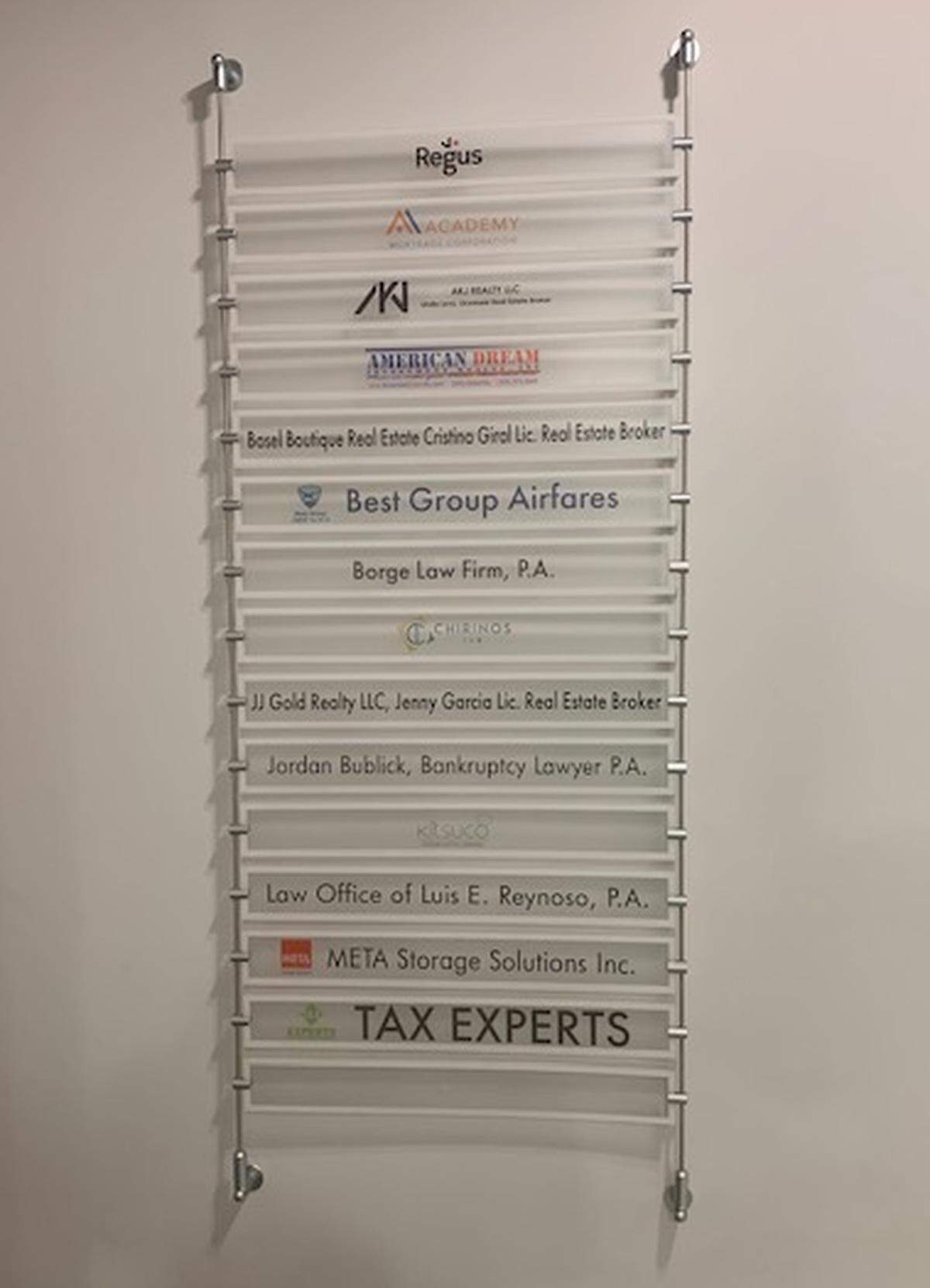 A list of placards at the office suite listed as Gelin Benefits Group’s address in North Miami.