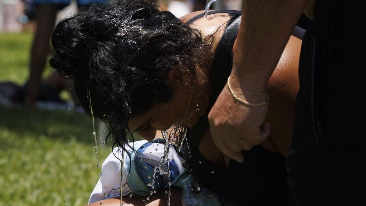 The Bonutti family, originally from Argentina, pours water on themselves at a watch party during a heat advisory as Argentina plays Egypt in the FIFA World Cup on Tuesday, July 7, 2026, at Lummus Park in Miami Beach.