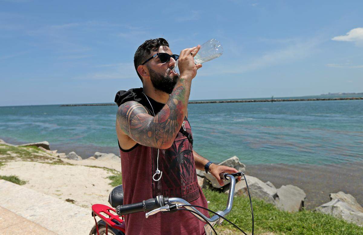South Florida resident Juan Rivarola drink water as he enjoyed the sunny and hot day at South Pointe Beach on Monday, June 3, 2019 in Miami Beach Fl.