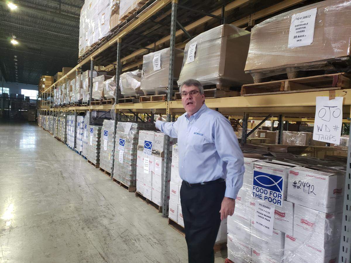Food for the Poor President/CEO Ed Raine shows nonperishable canned foods that are destined for Haiti. The Coconut Creek charity recently launched a $5 million emergency appeal on behalf of Haiti, where the humanitarian crisis is being exacerbated by gang violence.