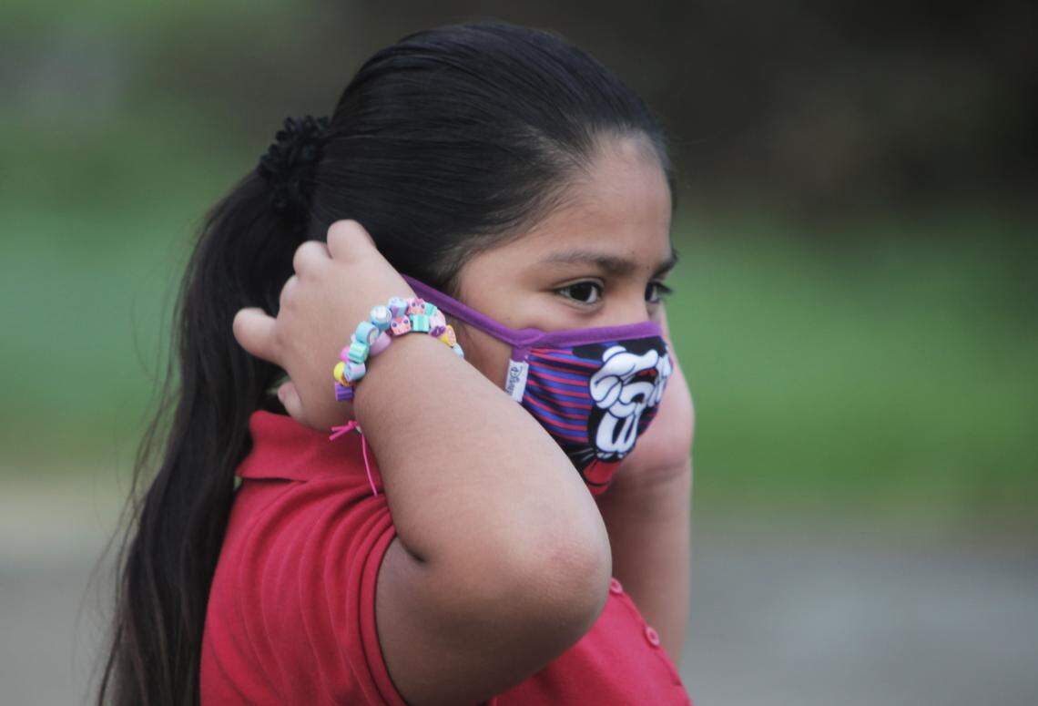 A student adjusts her mask in front of Redland Elementary upon returning to school on Oct. 5, 2020.