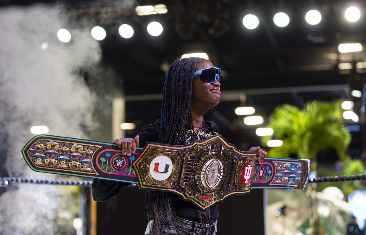 Amber Bellinger, 15, holds a college football themed belt as she visits the Playoff Fan Central at the Miami Beach Convention Center on Friday, Jan. 16, 2025, in Miami Beach, Fla. Fans can visit the event ahead of the College Football Playoff National Championship Game between the Miami Hurricanes and the Indiana Hoosiers and enjoy a variety of family-friendly interactive experiences.