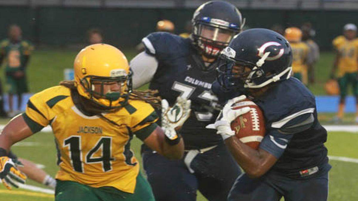 Chris Henderson of Columbus runs for yardage against Jackson High on Wednesday, August 26, 2015 at Tropical Park. The game was stopped by bad weather and resumed Friday, with Columbus winning 38-25.
