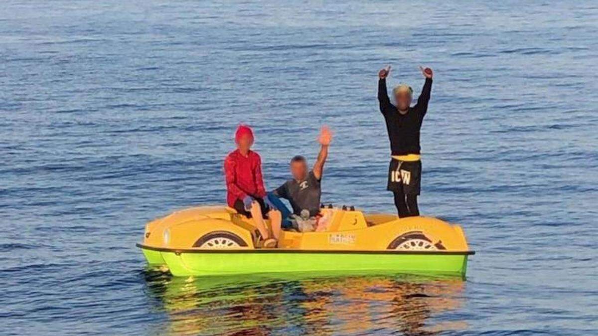 Three men from Cuba wave at members of the U.S. Coast Guard on what appears to be a pedal boat common at many resorts. The Coast Guard stopped the vessel Saturday, July 9, 2022, about 70 miles from Key West.