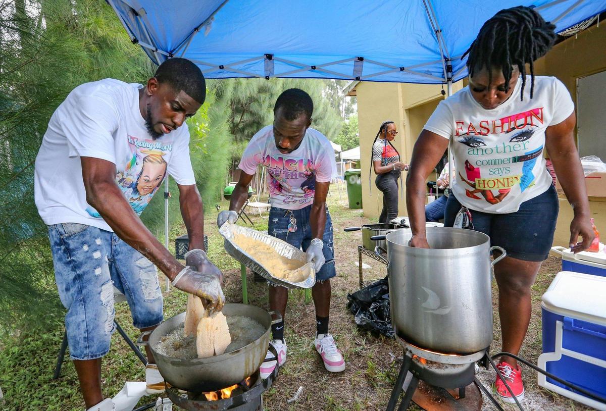 Seven months after a tragic hit-and-run in Wilton Manors that killed Laziyah Stukes, 10, and two other girls and left several children injured, Laziyah’s mother, Devera Stukes, holds a balloon release and fish fry to help raise money to pay for her daughter’s funeral. From left, Andre Fleming, Noble Williams and Chelsea King prepare food as friends and family gather at the Fort Lauderdale home on Saturday, July 16, 2022.