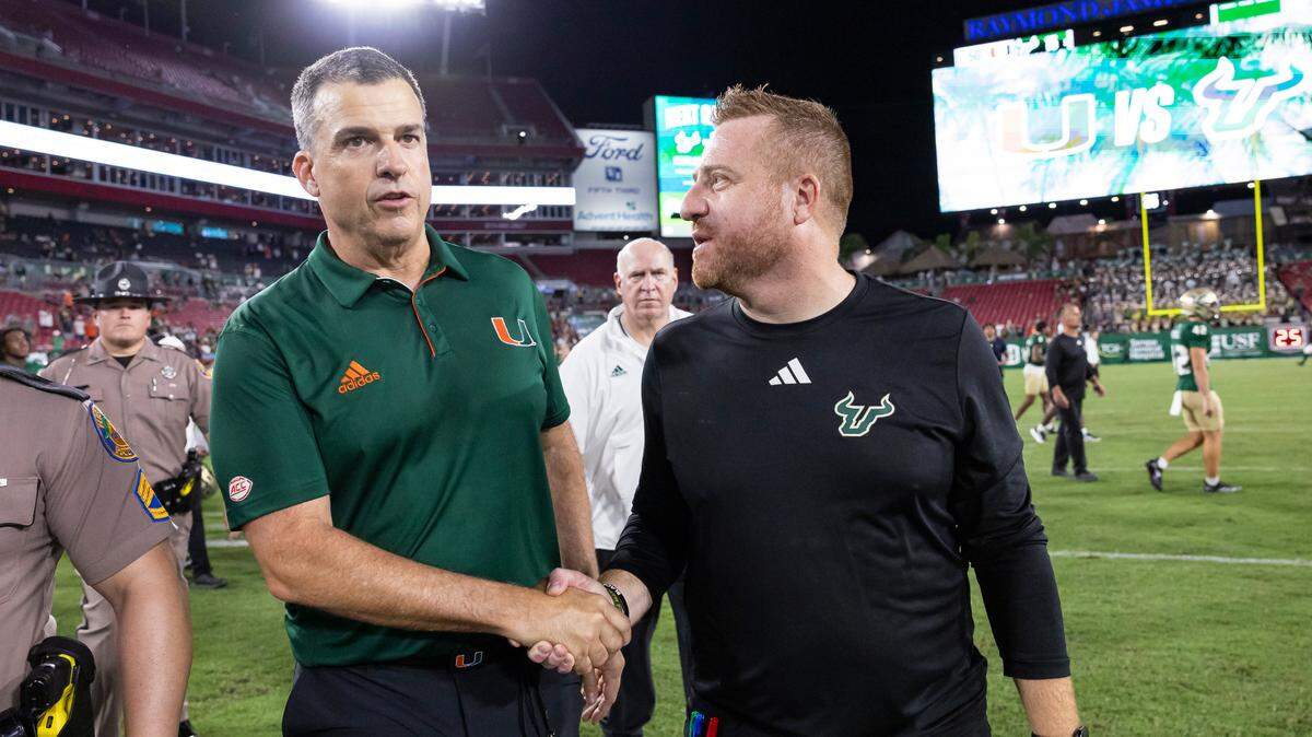 Miami Hurricanes head coach Mario Cristobal and South Florida Bulls head coach Alex Golesh shake hands after this NCAA college football game at the Raymond James Stadium on Saturday, Sept. 21, 2024, in Tampa, Fla.