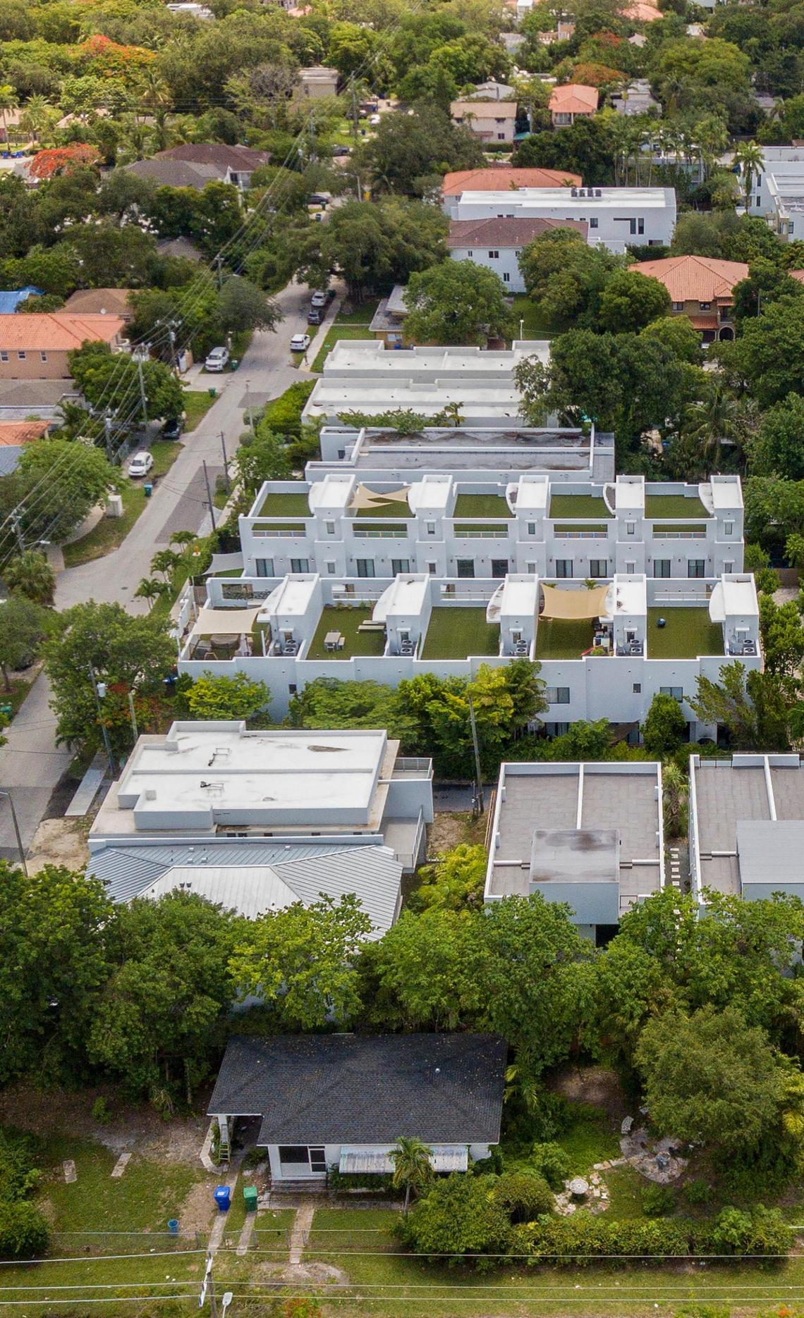 Luxury homes and townhouses with rooftop gardens rise along what was once a street of modest homes in Miami’s historically Black West Coconut Grove on Friday, June 17, 2022. The Black community is rapidly disappearing amid gentrification.