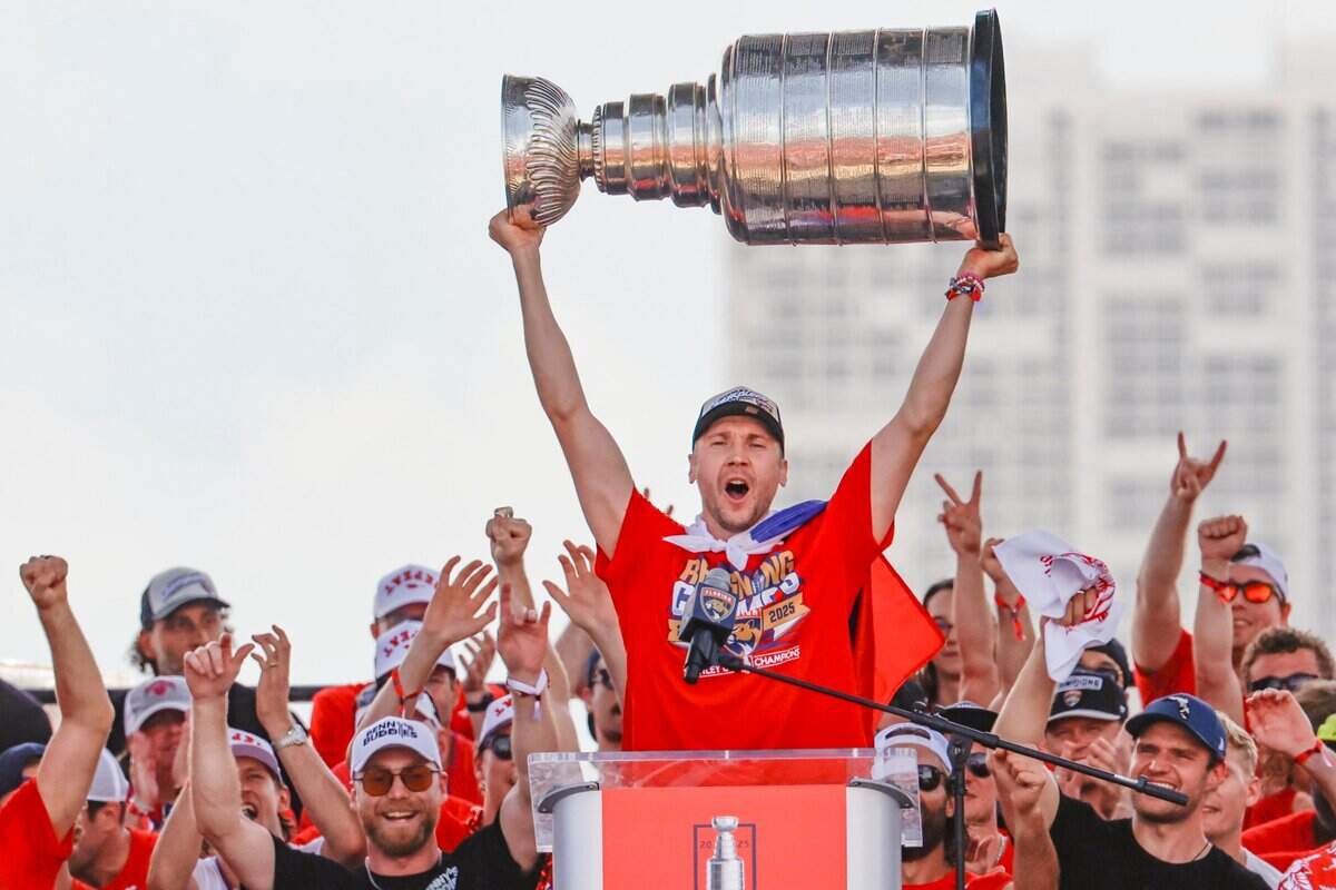 Florida Panthers goaltender Sergei Bobrovsky hoists the Stanley Cup as teammates celebrate on stage during the team’s victory parade and rally along A1A in Fort Lauderdale, Florida, on Sunday, June 22, 2025