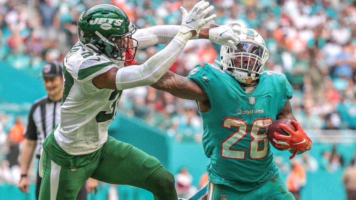 Miami Dolphins running back Duke Johnson (28) stiff arms New York Jets cornerback Bryce Hall (37) as he runs for a first down at Hard Rock Stadium in Miami Gardens on Sunday, December 19, 2021.