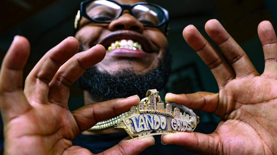 Phillip “Philo” Norville displays the logo of Lando Golds, a shop in Miami that specializes in custom grillz. 