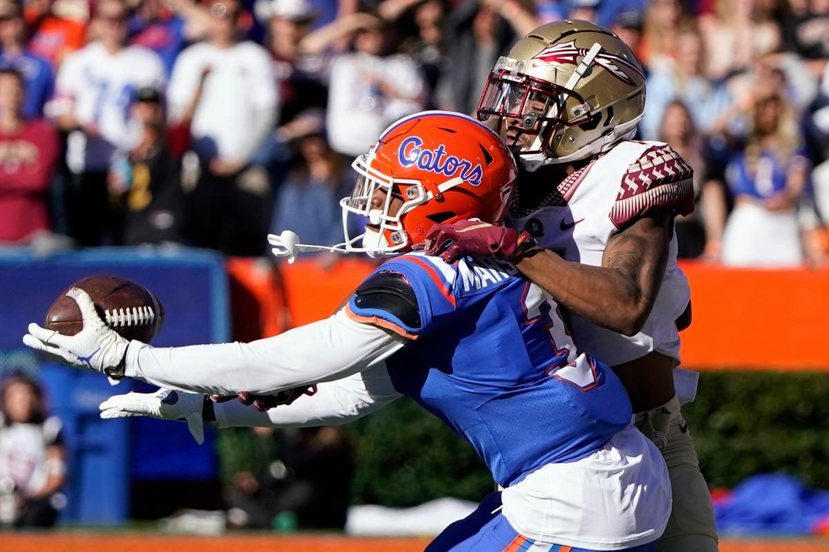Florida cornerback Jason Marshall Jr., left, intercepts a pass intended for Florida State wide receiver Andrew Parchment during the second half of an NCAA college football game, Saturday, Nov. 27, 2021, in Gainesville, Fla. (AP Photo/John Raoux)