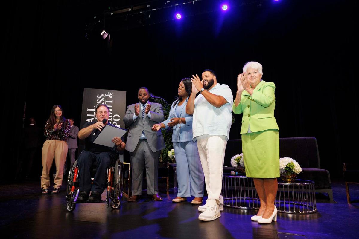 Mayor Evan Piper, left, reads a proclamation to DJ Khaled, second from right, and other commission members making May 8 “DJ Khaled Day.”