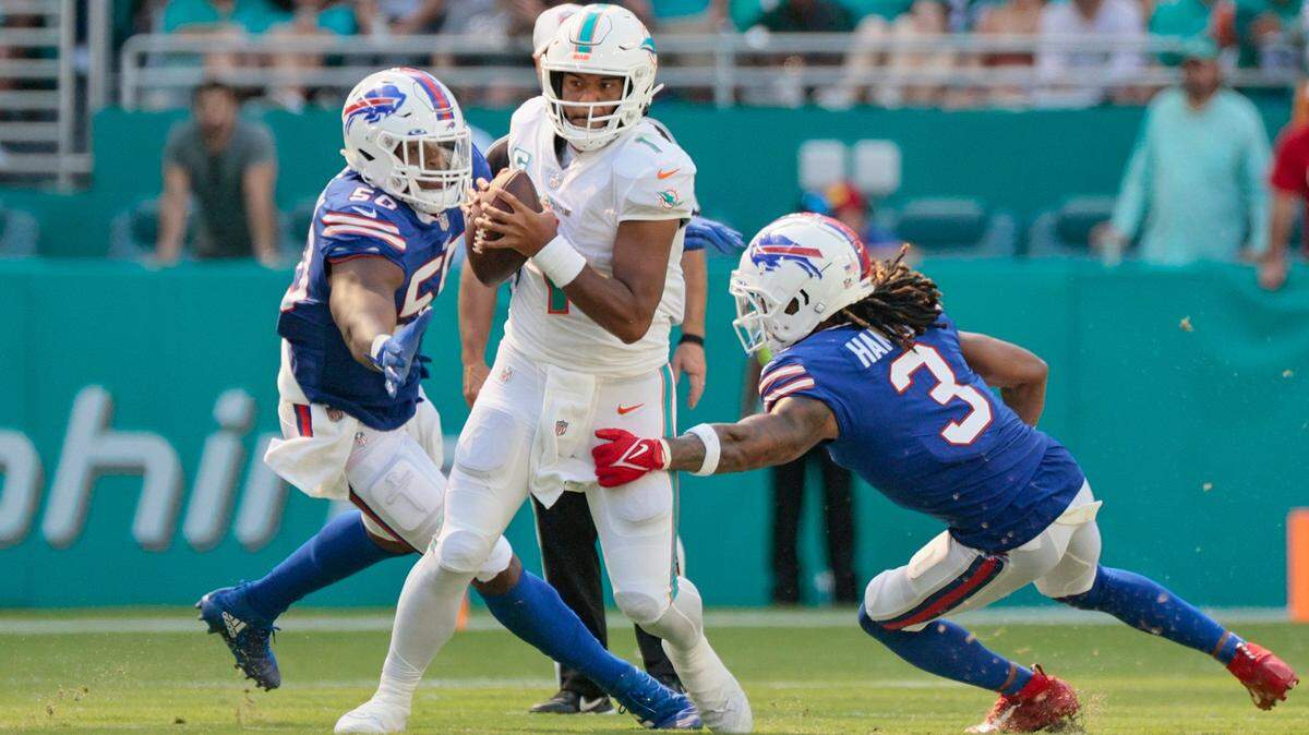 El quarterback de los Miami Dolphins, Tua Tagovailoa (1), corre mientras es perseguido por los defensores de los Buffalo Bills en la segunda mitad en el Hard Rock Stadium en Miami Gardens el domingo 25 de septiembre de 2022.