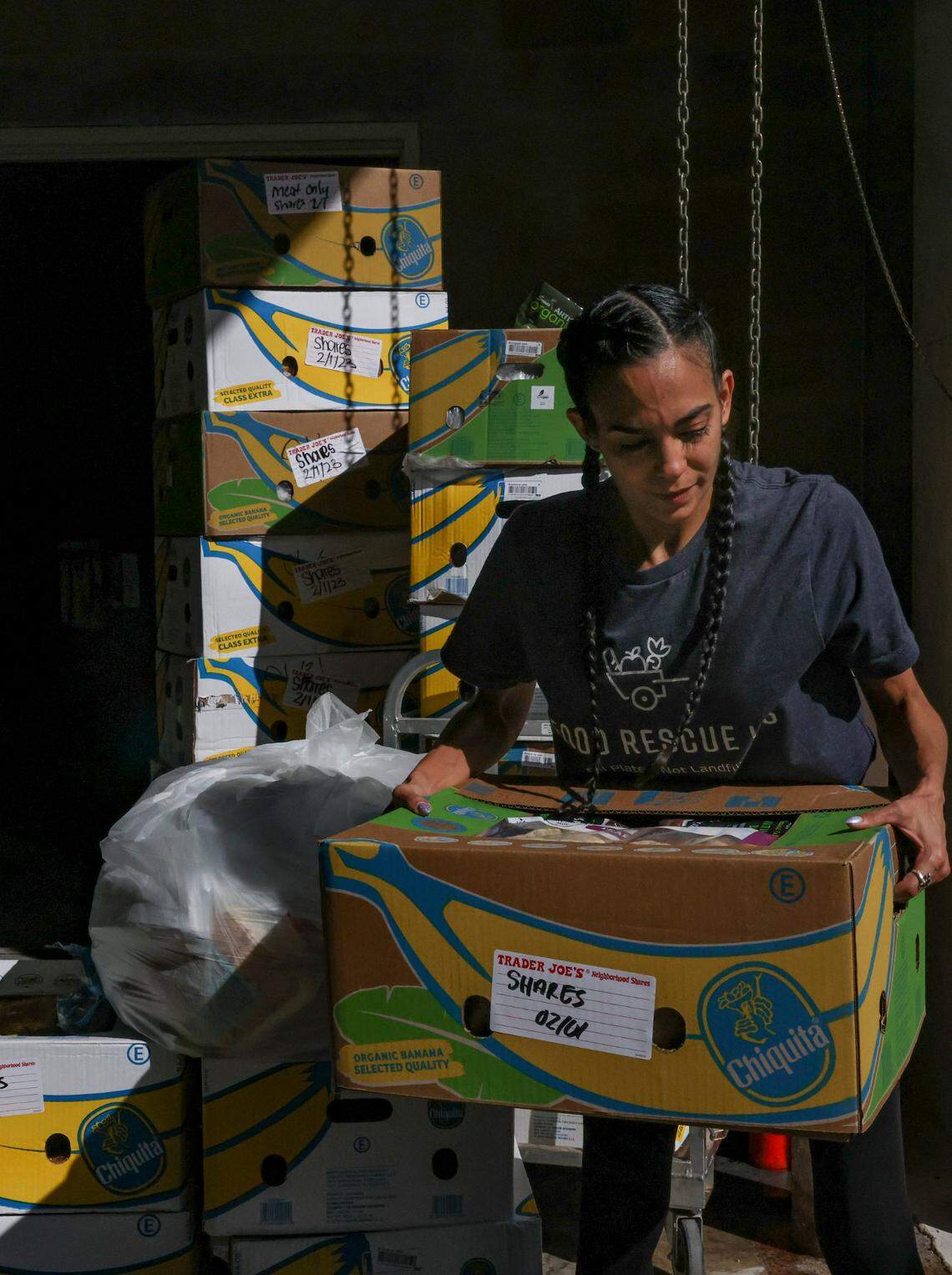 Food Rescue US volunteer Linda Diaz-Cobo picks up a box of food from Trader Joe’s that would otherwise be thrown out. “Giving food to someone who’s hungry is probably the most powerful thing you can do,” she said.