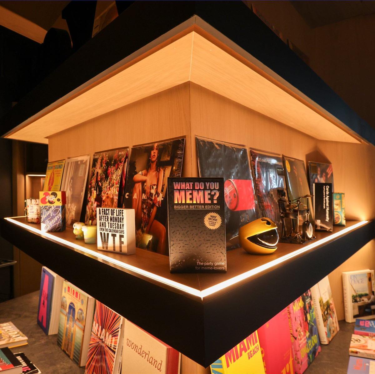 The Moxy Miami Wynwood Hotel features shelves with books, games, and other playful items for guests to engage with near its Check-In bar in Miami, Florida, on Monday, July 29, 2024. Wynwood’s artistic and creative spirit, a second-level bar that doubles as a Check-In desk, stylish communal spaces, and innovative touches create a fun and contemporary ambiance. The playful sign says it all: guests are welcome at the Check-In desk on Monday, July 29, 2024, in Miami, Florida.