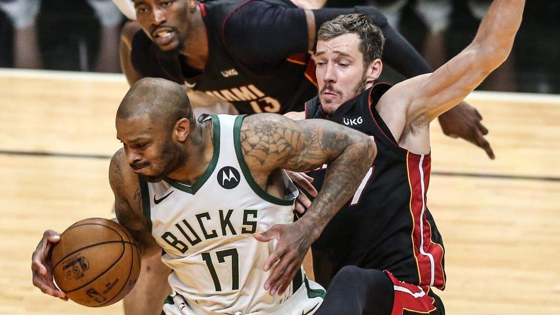 Milwaukee Bucks forward P.J. Tucker (17) on a rebound as he fights off Miami Heat center Bam Adebayo (13) and Goran Dragic (7) in the fourth quarter during round 1, game 4 of the NBA playoffs at the AmericanAirlines Arena in Miami on Saturday, May 29, 2021.
