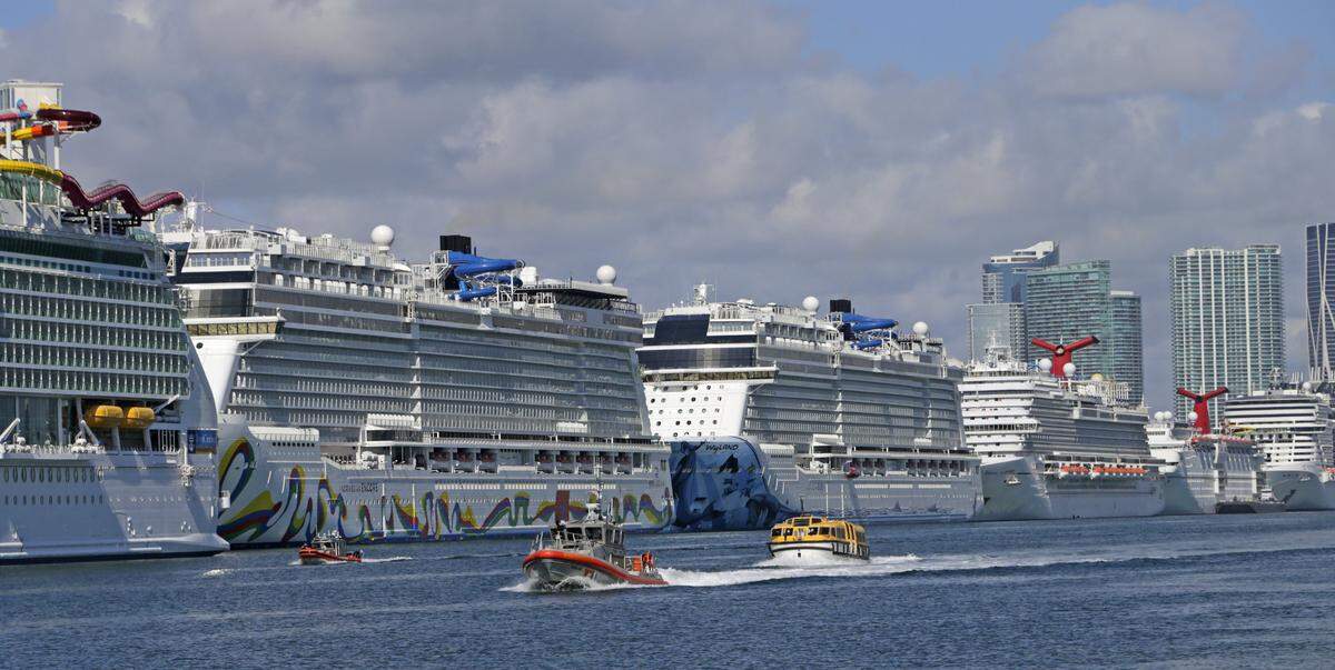 Lifeboats escorted by the U.S. Coast Guard bring sick crew members into PortMiami from cruise ships anchored off the coast on Monday, March 30, 2020, in Miami.