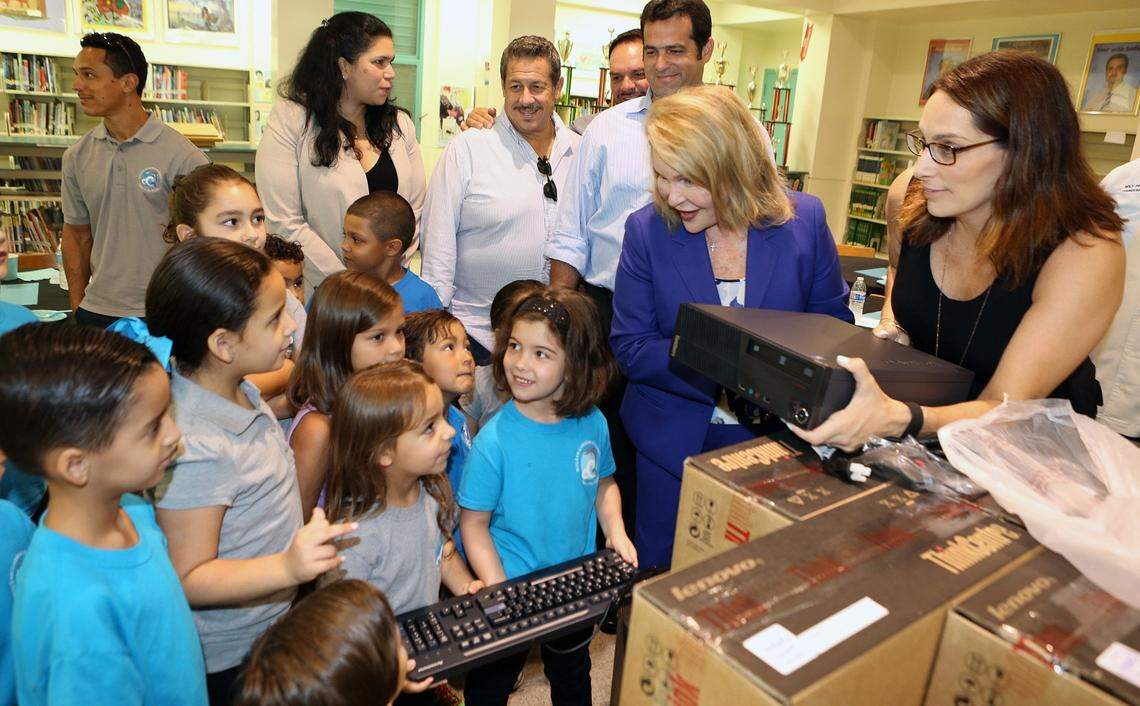 Perla Tabares Hantman (center) presenting Miami-Dade students with new computers at the beginning of the 2015 school year, along with former Hialeah Gardens Elementary School Principal Rachel Autler (right) and then-mayor of Hialeah Gardens, Yioset de la Cruz and former Miami-Dade County Commissioner Jose Pepe Diaz.