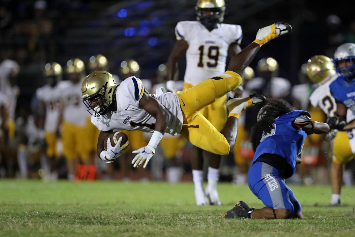 St. Thomas Aquinas defensive back King Mack is tripped up by Dillard running back Jordan Reeds during the first half on Friday, Oct. 7, 2022 in Fort Lauderdale.