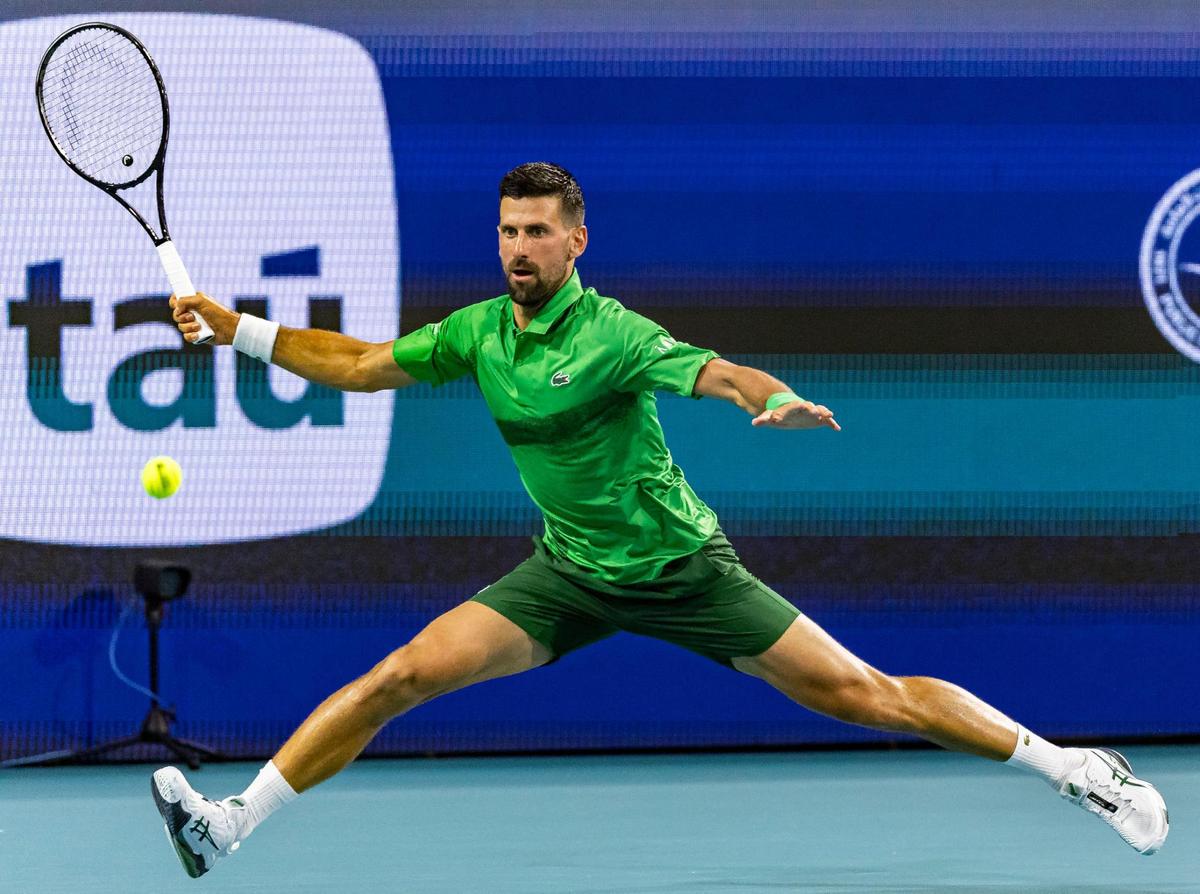 Novak Djokovic, of Serbia, returns the ball against Lorenzo Musetti, of Italia, during their match at the Miami Open tennis tournament on Tuesday, March 25, 2025, at Hard Rock Stadium in Miami Gardens, Fla.