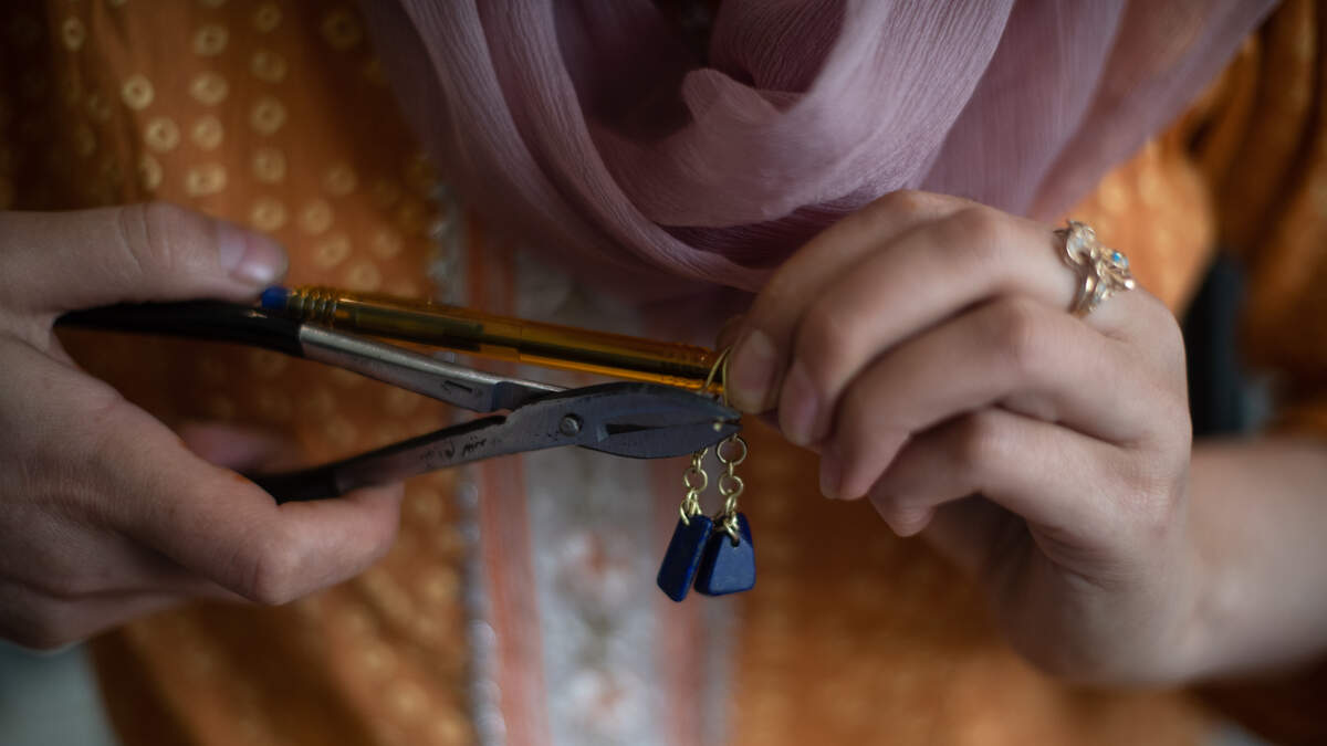 An Afghan woman who fled Afghanistan after the fall of Kabul in 2021 makes earrings during a class run by jeweler and teacher Javid Noori, who trained students in the craft of jewelry making in Afghanistan, at a guesthouse run by the Future Brilliance charity on April 28, 2023 in Islamabad, Pakistan.