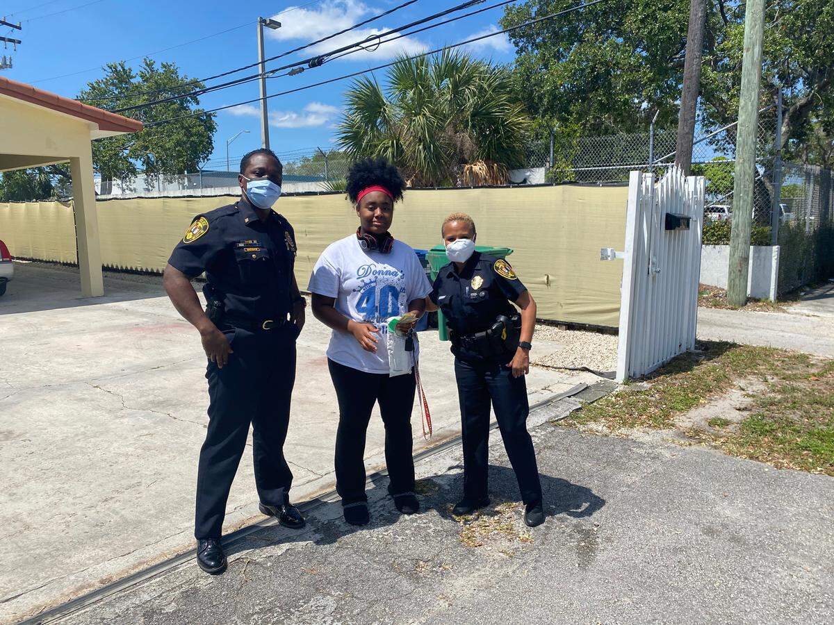 North Miami police officers Kessler Brooks, left, and Natalie Buissereth, right, visit with Police Athletic League (PAL) member 15-year-old Akai Blocker, center, on Wednesday. North Miami Police Chief Larry Juriga said Buissereth, who runs the PAL program, “plays a critical role in the lives of these young children.”