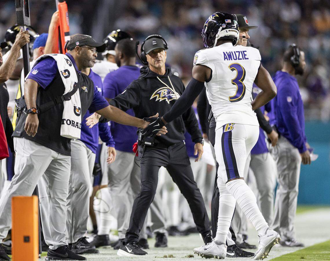 Baltimore Ravens head coach John Harbaugh high-fives cornerback Chidobe Awuzie (3) after a play against the Miami Dolphins in the first half of an NFL game at Hard Rock Stadium on Thursday, Oct. 30, 2025, in Miami Gardens, Fla.