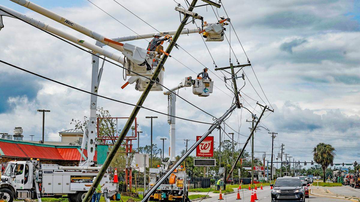 Power line repair crew members work on damaged electrical poles caused by Hurricane Idalia in Perry, Florida on Wednesday, August 30, 2023.