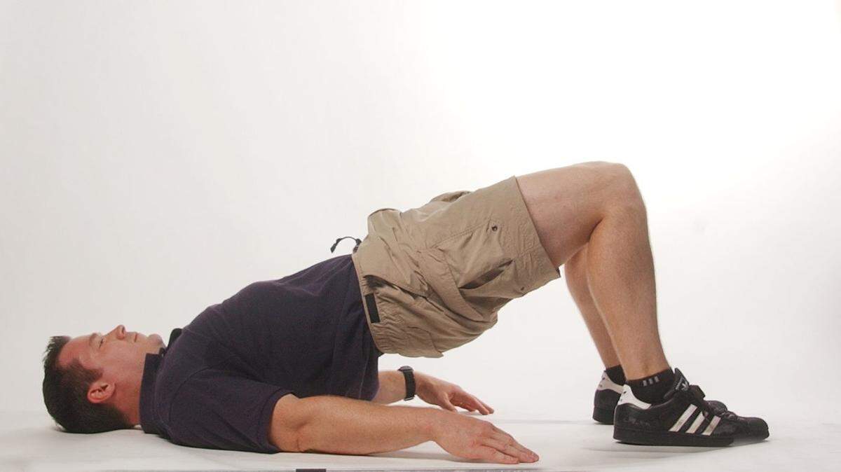 Geoff Neupert demonstrates the midpoint position of the hip bridge, which is a good exercise to prevent hip injuries from running or working out.